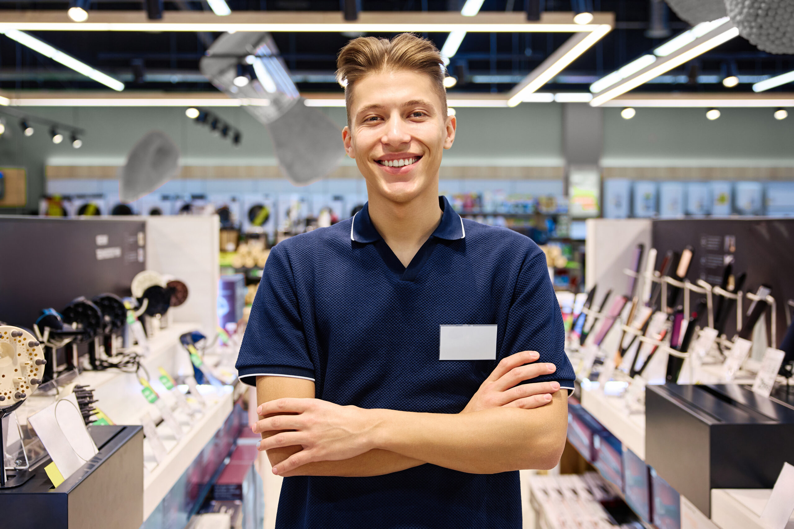 A Smiling Retail Employee Working in a Modern Store Surrounded by Various Merchandise Items Happy caucasian male makes notes while on a virtual call