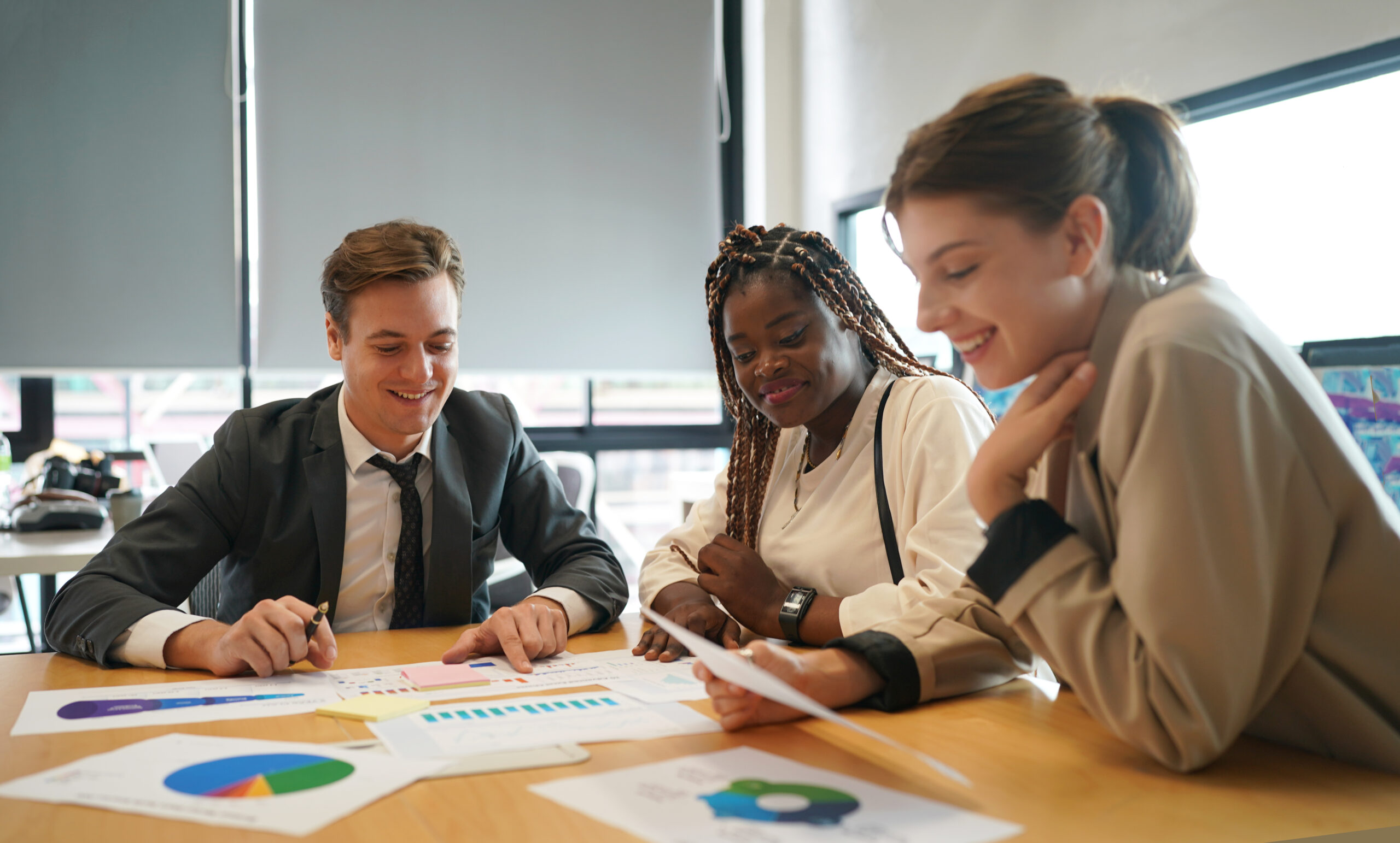 Young woman with black glasses and a white t-shirt shaking hands with a hiring manager.
