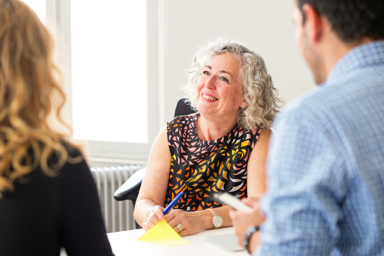 Middle aged business woman in meeting with man and woman