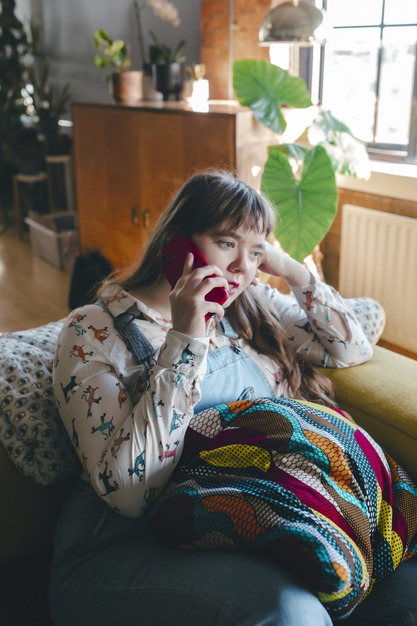 Care-experienced young person speaking on the phone in a relaxed setting, representing support for care-experienced young people.