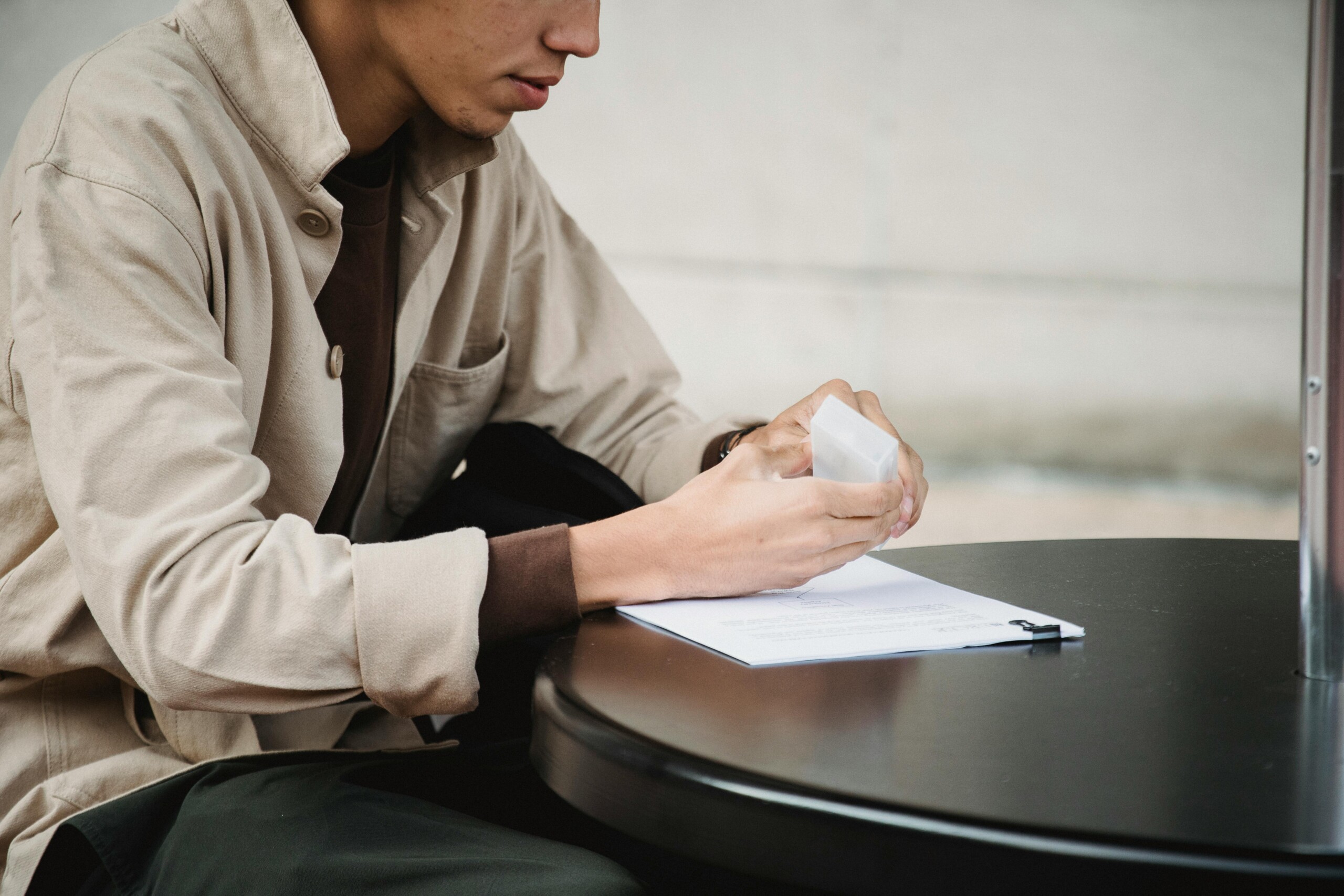 pexels-rodnae-productions-7414041 Person writing at a round black table outdoors