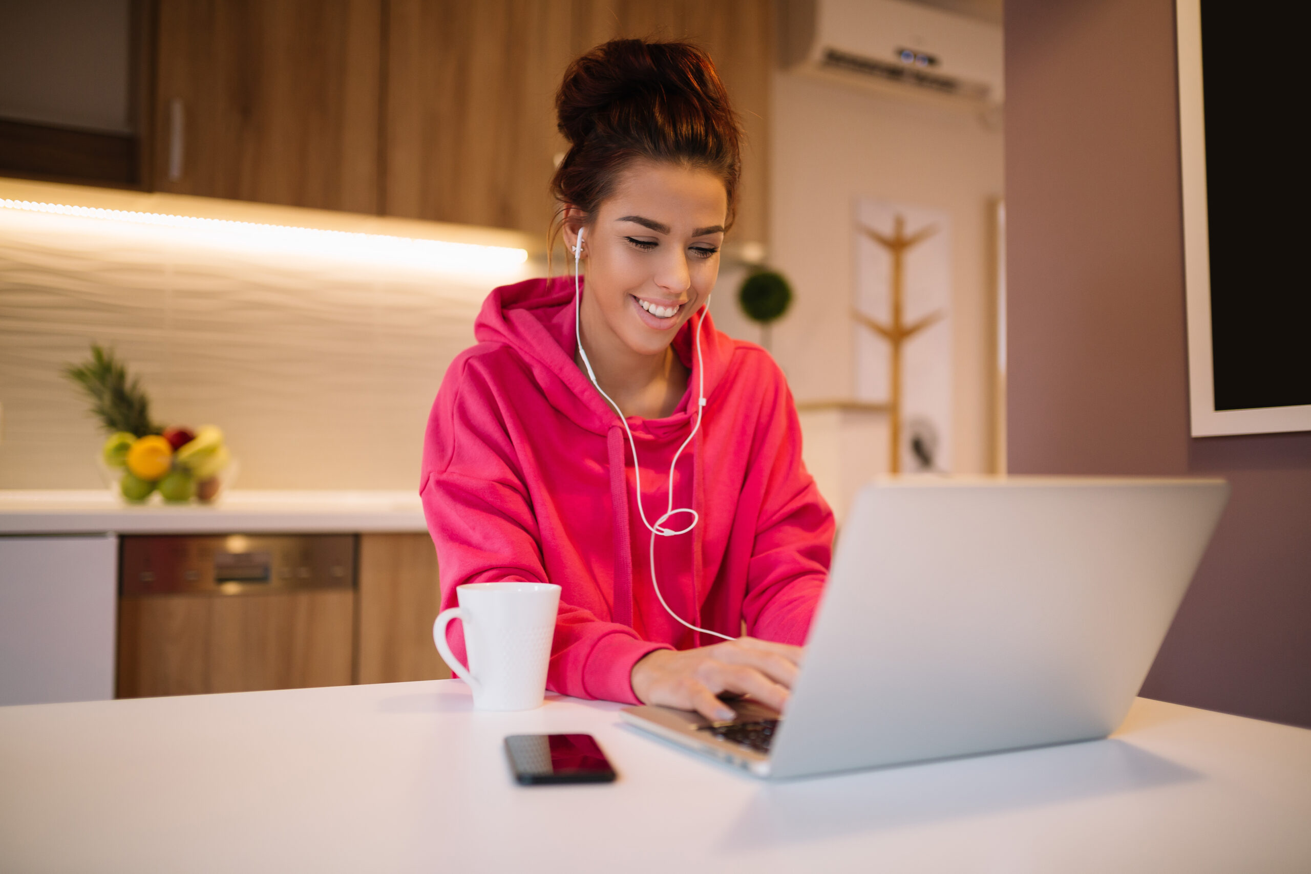 relaxed smiling young brunette with headphones on a virtual call on laptop