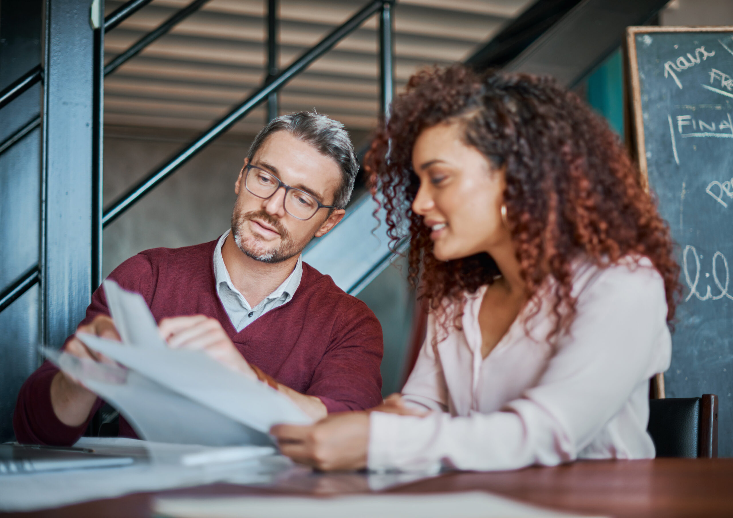 A man and woman looking over policy document paperwork together
