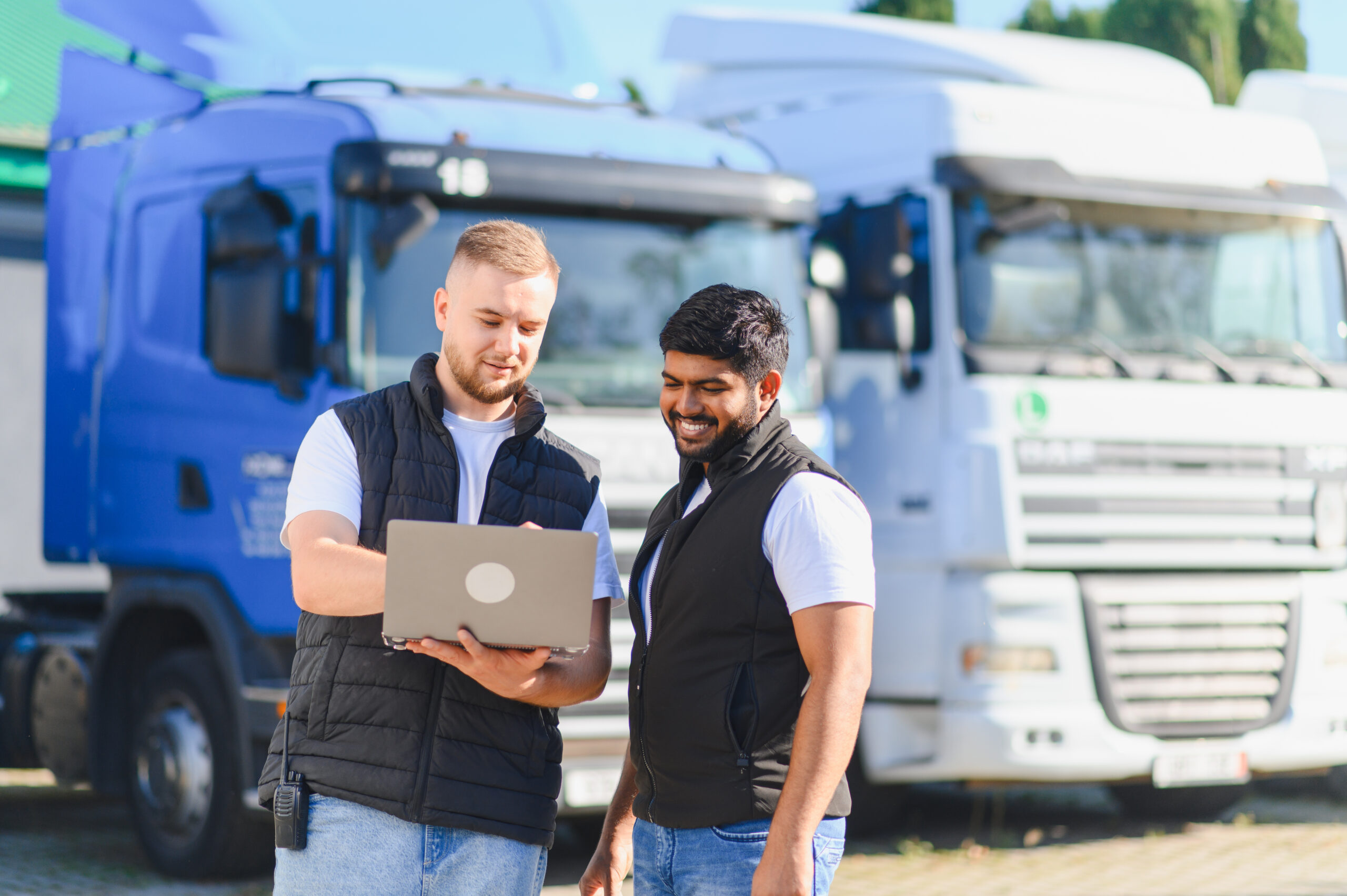 truck-drivers-discussing-logistics-using-laptop-by