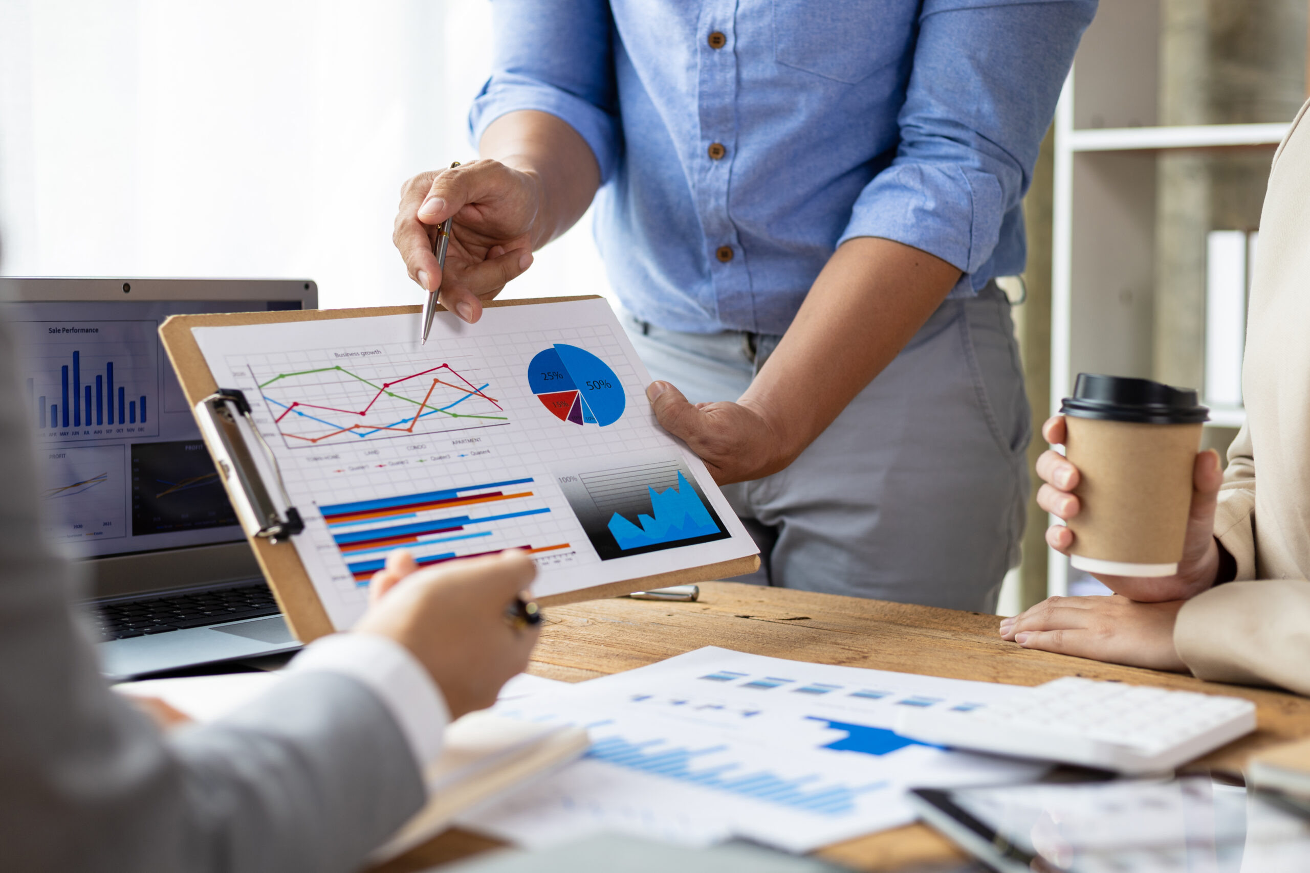 a picture of two business professionals from the next down holding a sales and marketing data chart